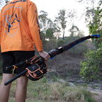 Person holding black and orange spinning reel case